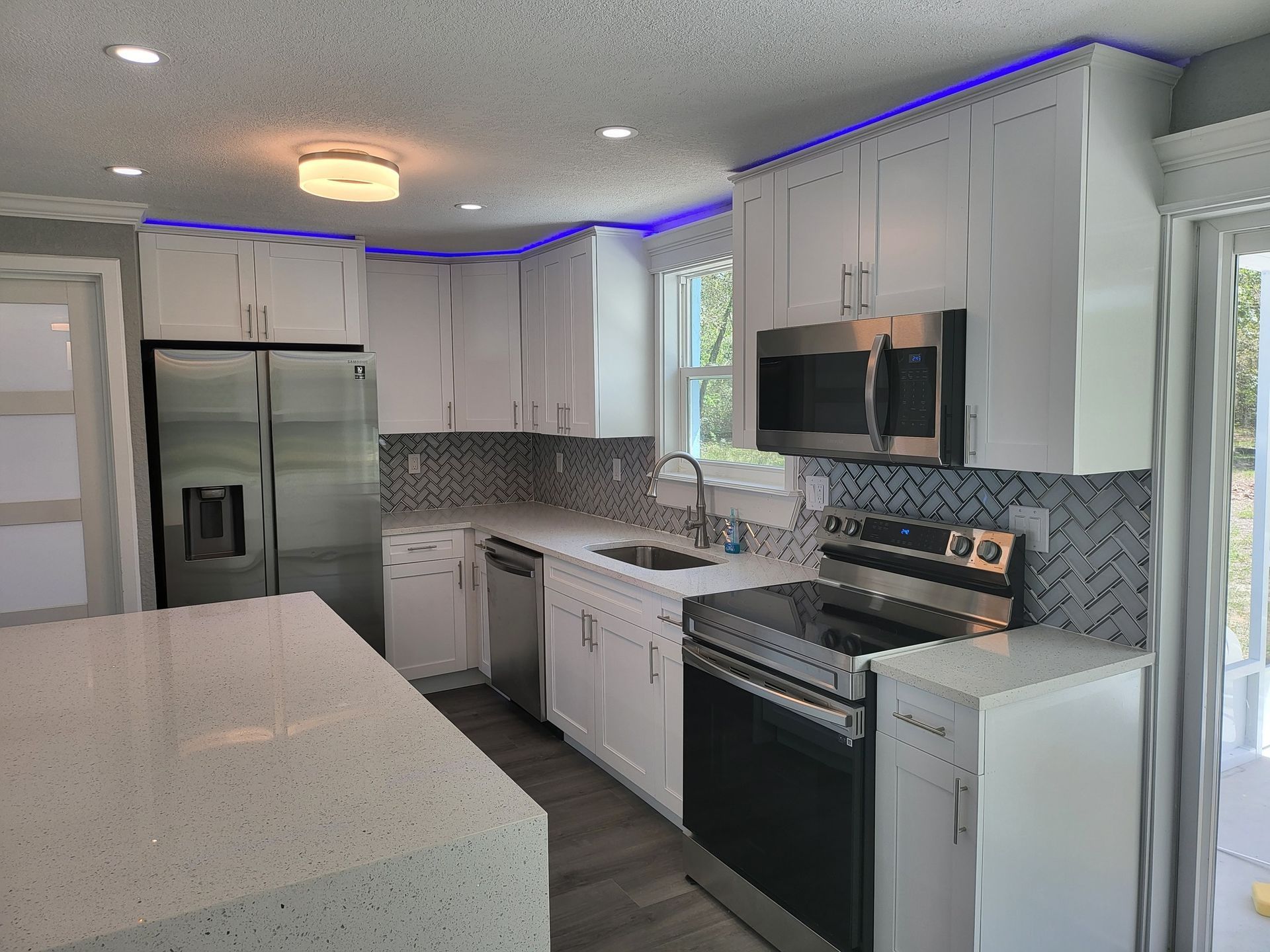 A kitchen with white cabinets and stainless steel appliances