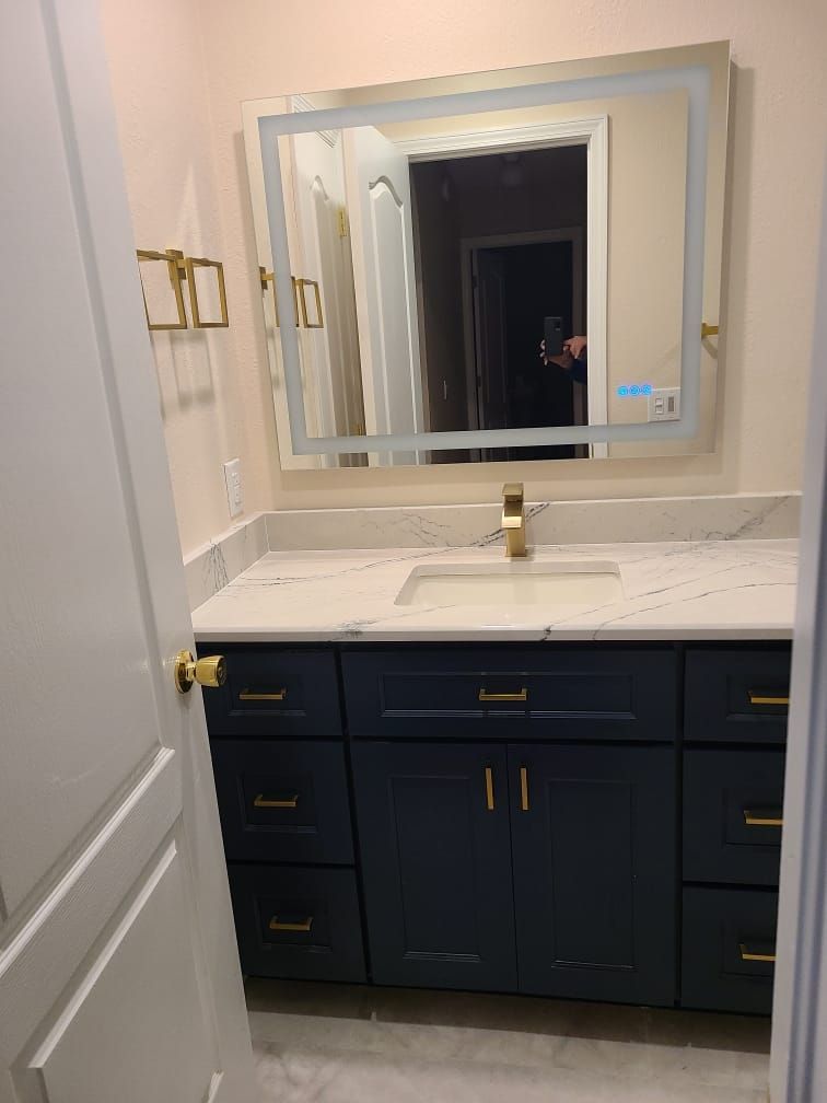 A bathroom with a sink , mirror and drawers.