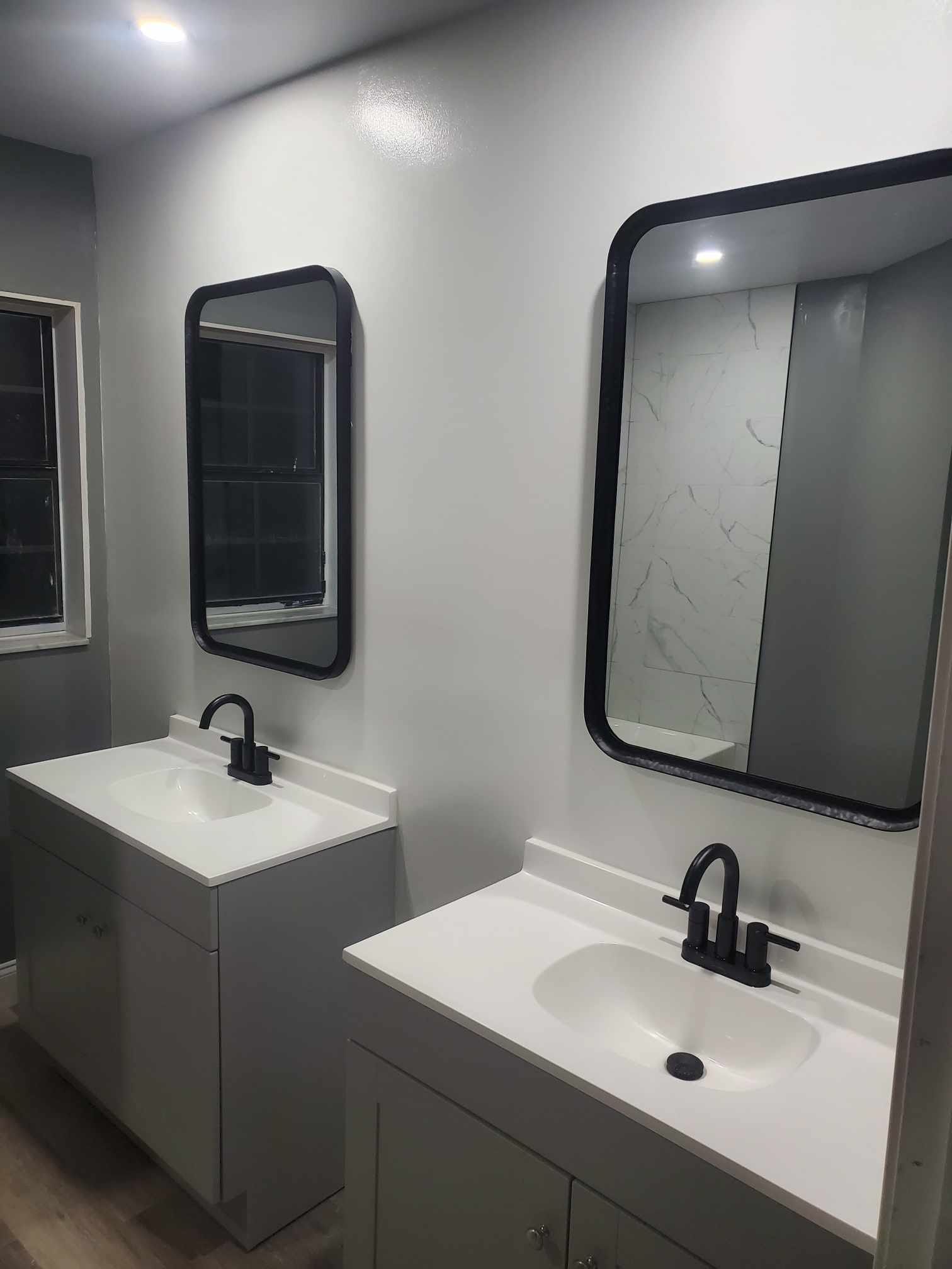 A bathroom with two sinks and two mirrors.