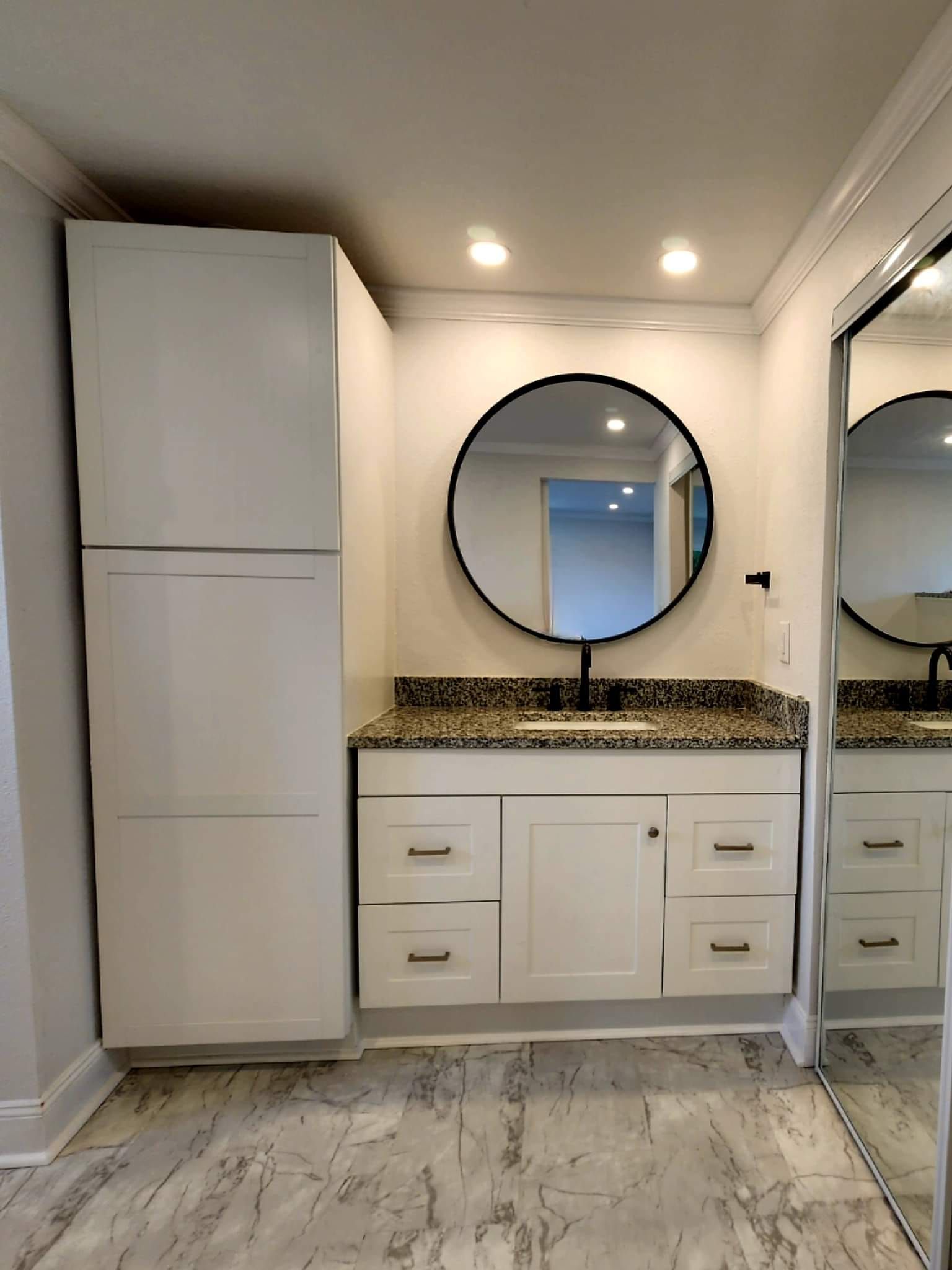 A bathroom with a sink , mirror and cabinets
