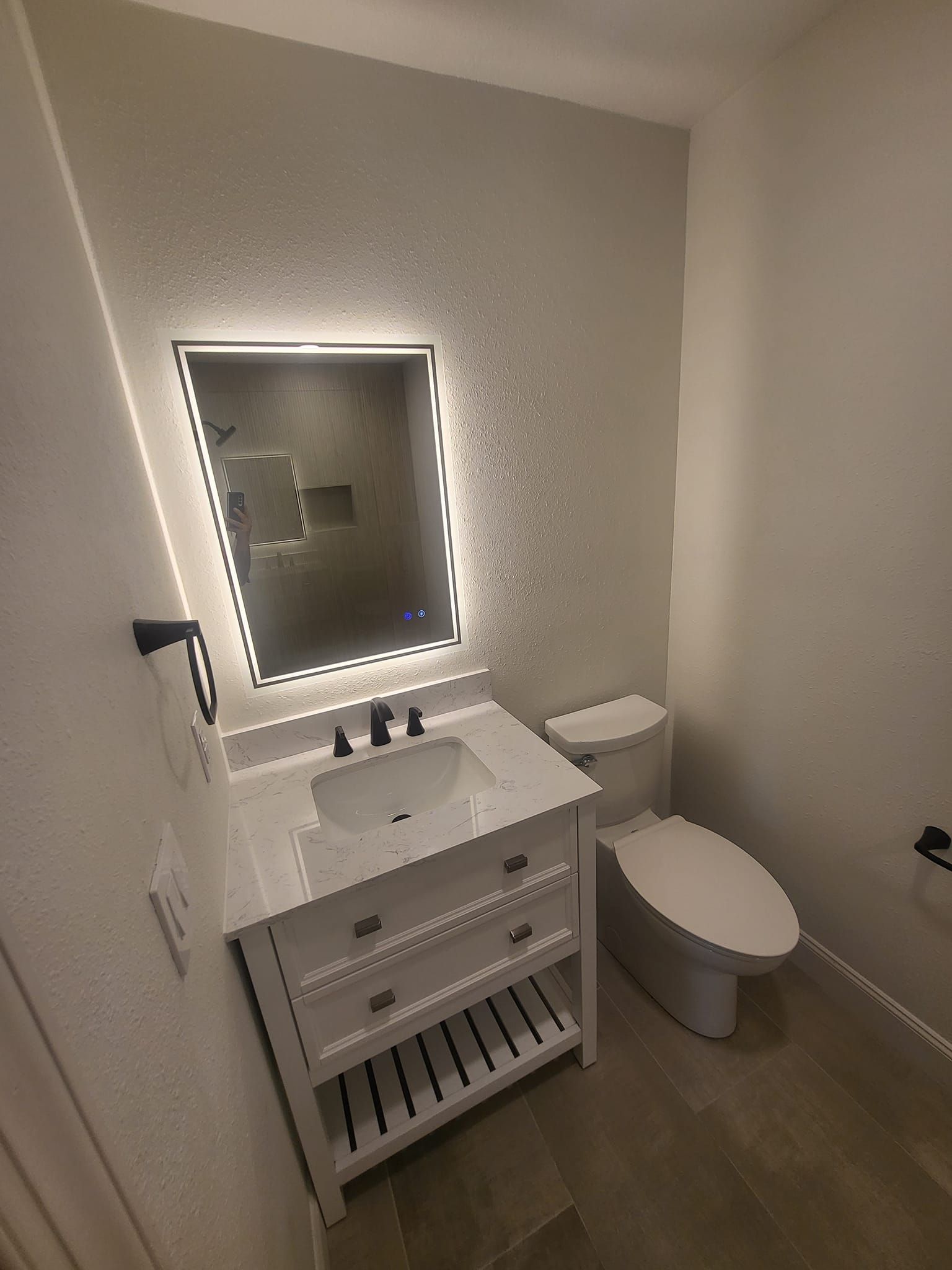 A bathroom with a sink , toilet and mirror.