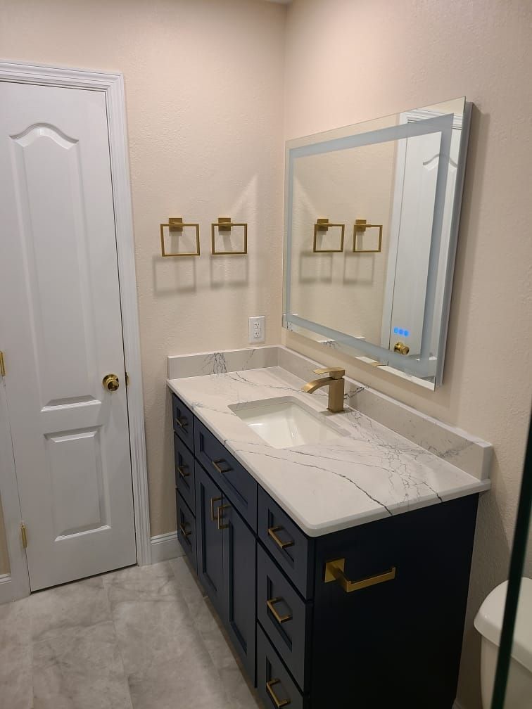 A bathroom with a sink , mirror and cabinets.