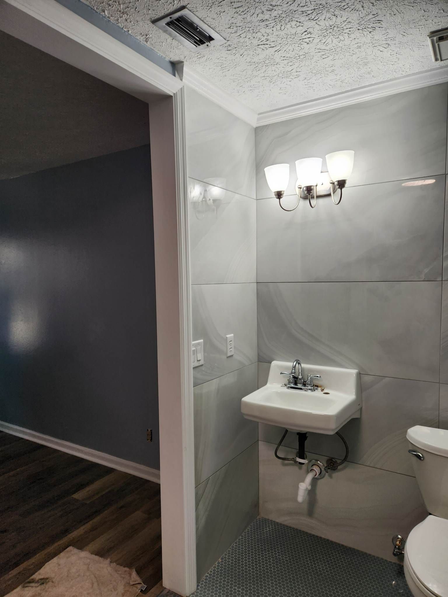 A bathroom with a sink , toilet and mirror.