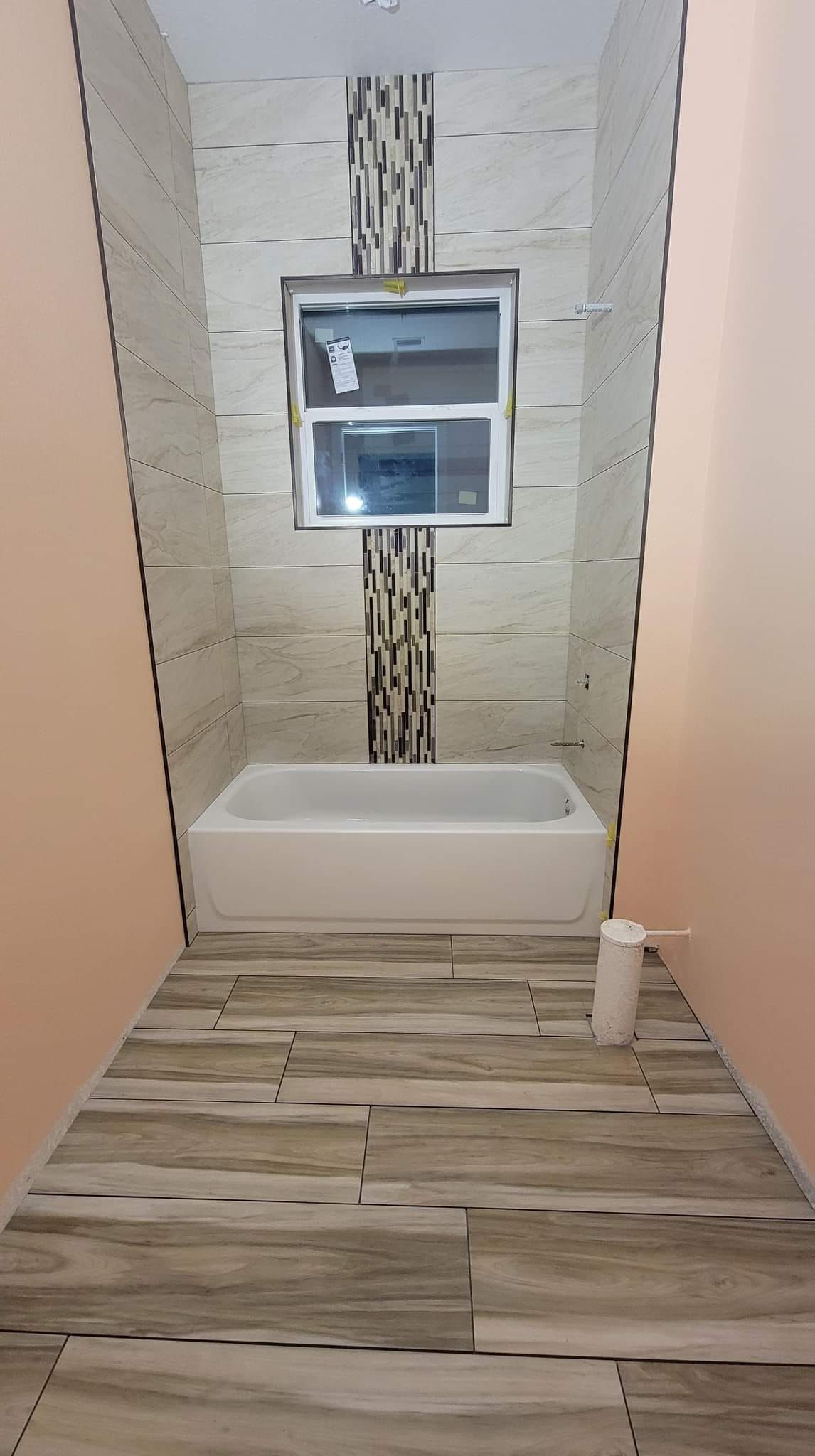 A bathroom with a bathtub and a window.