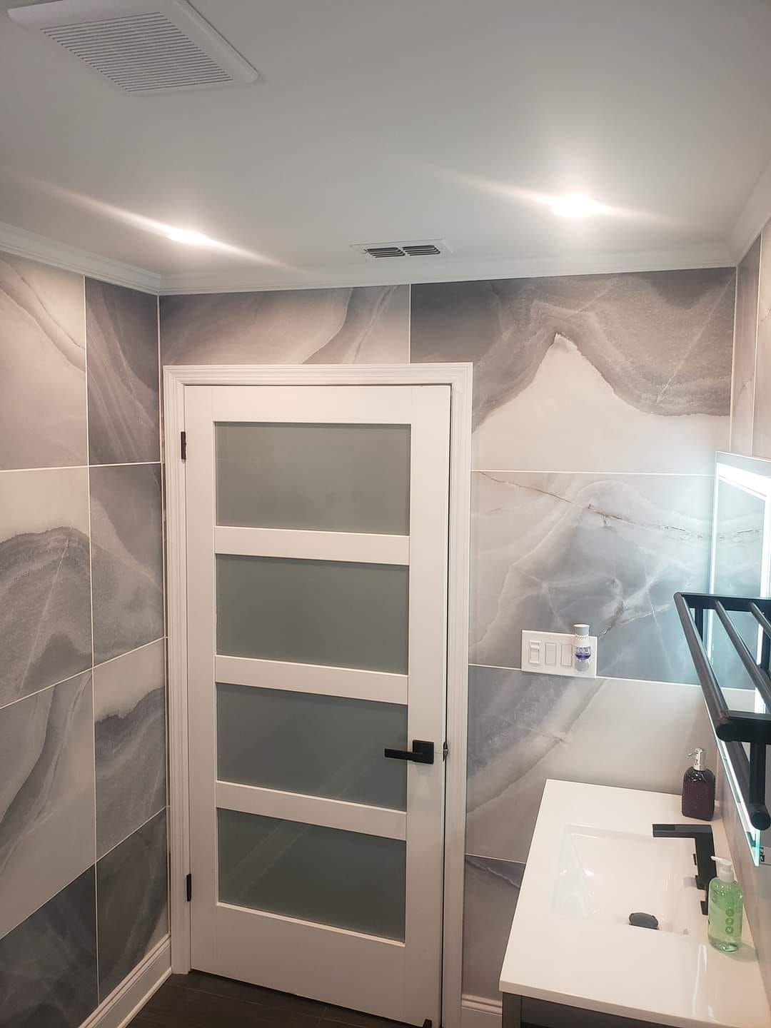 A bathroom with a white door and a sink