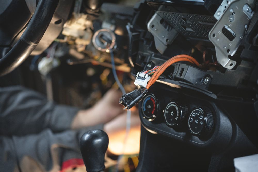 A Person is Working on the Dashboard of a Car — Regional Auto Electrics In Thirroul, NSW