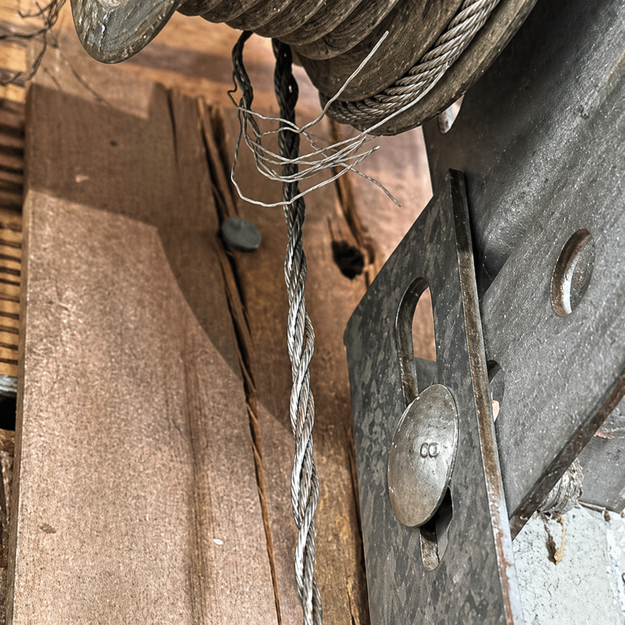 Coiled gray steel cable with metal fittings and two looped ends