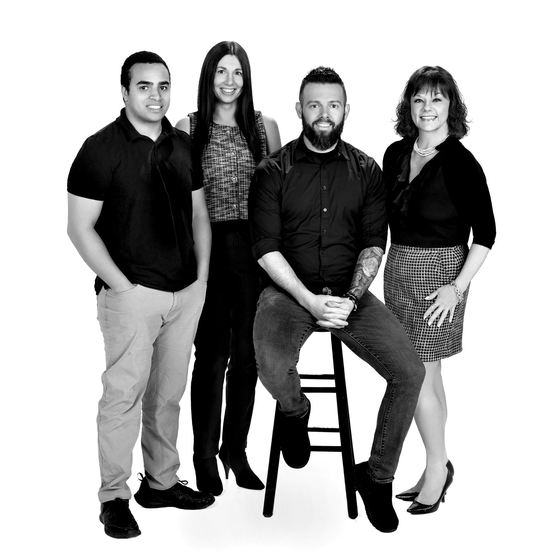 A man is sitting on a stool next to two women