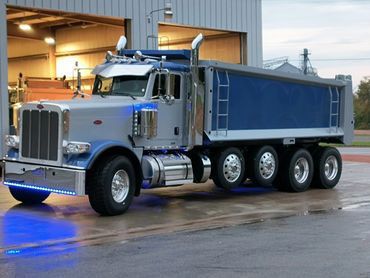 A Blue Dump Truck is Parked in Front of a Garage