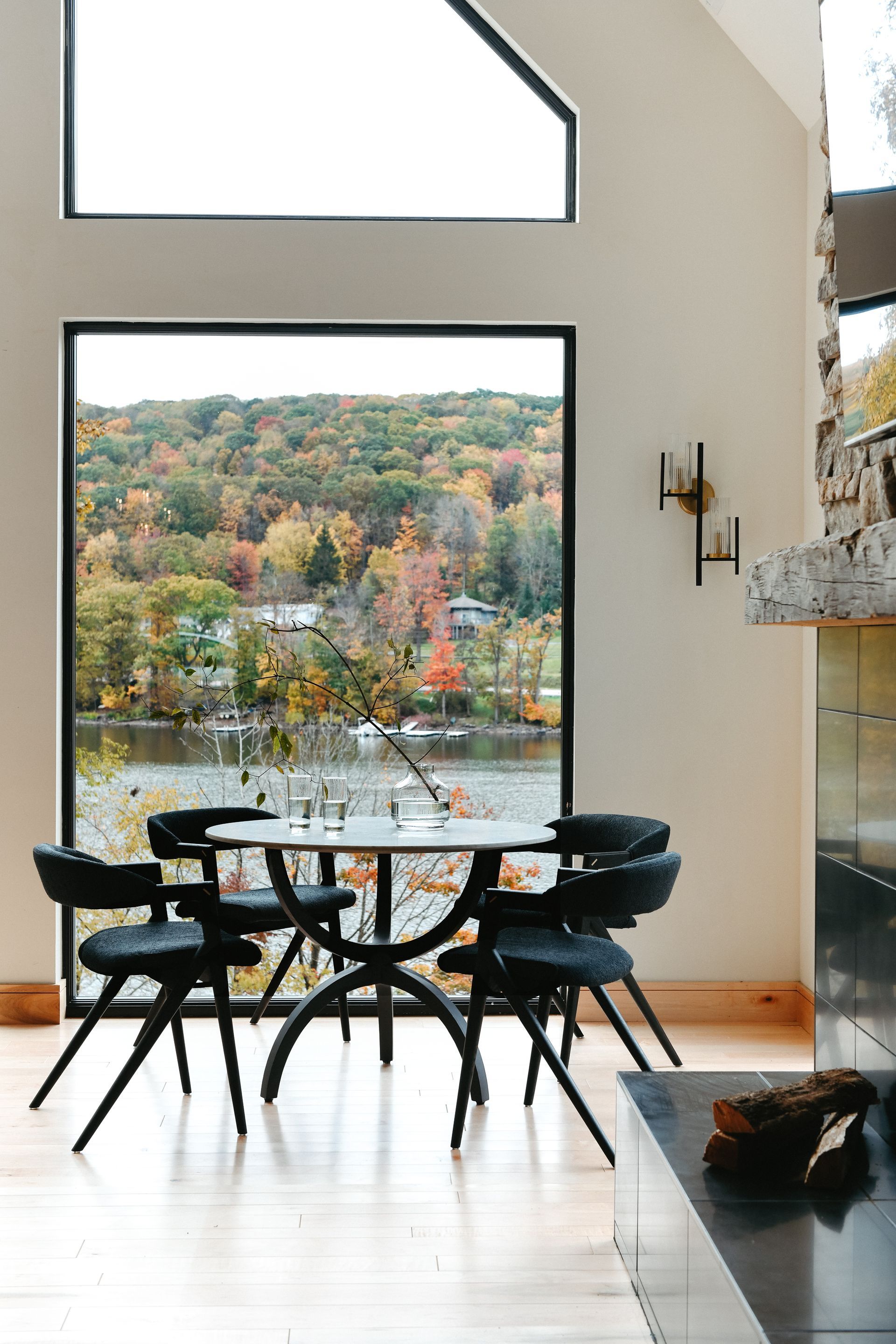 A dining room with a table and chairs and a large window overlooking Deep Creek Lake