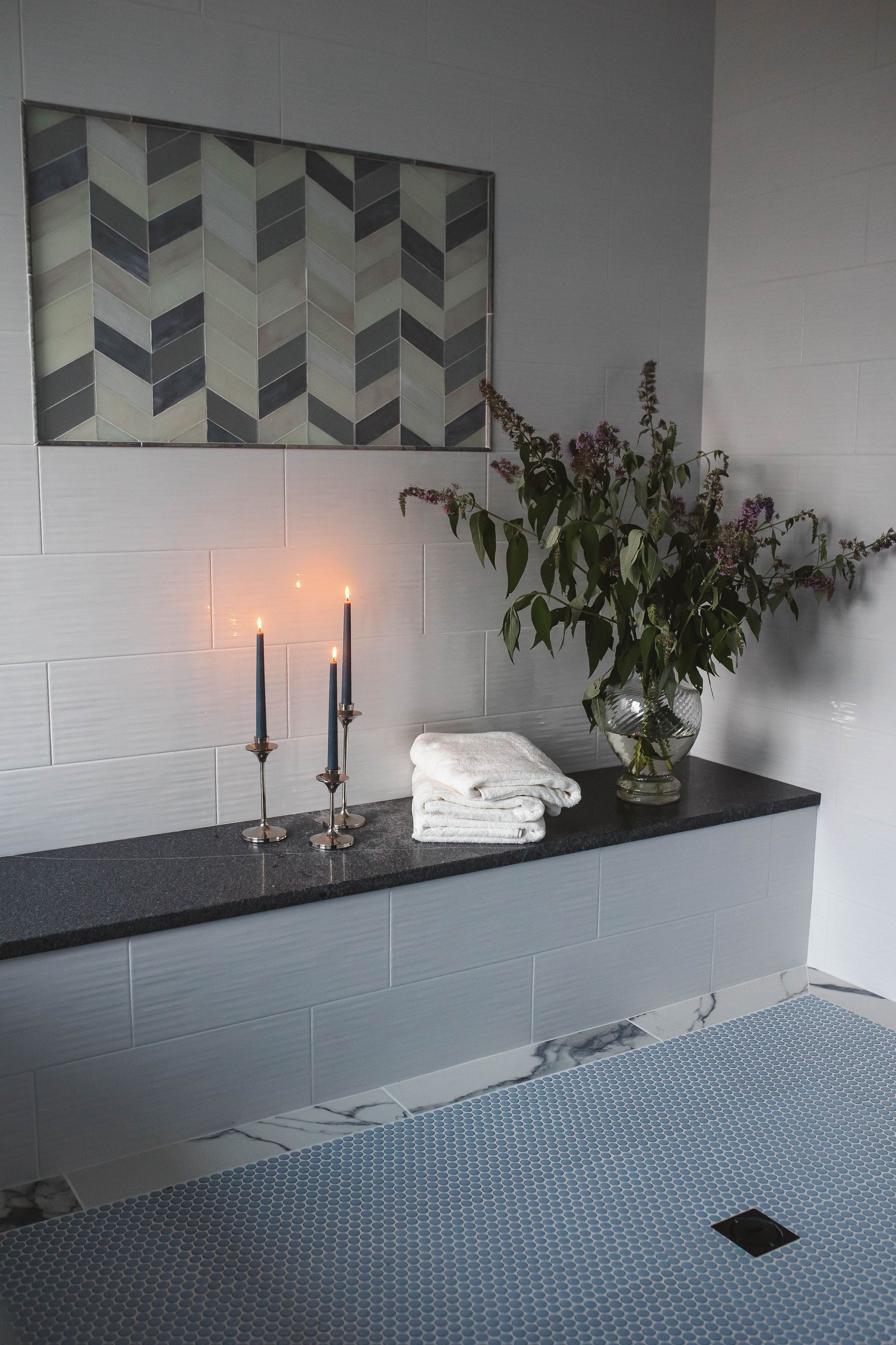 Delray bathroom with two candles and a vase of flowers on the countertop