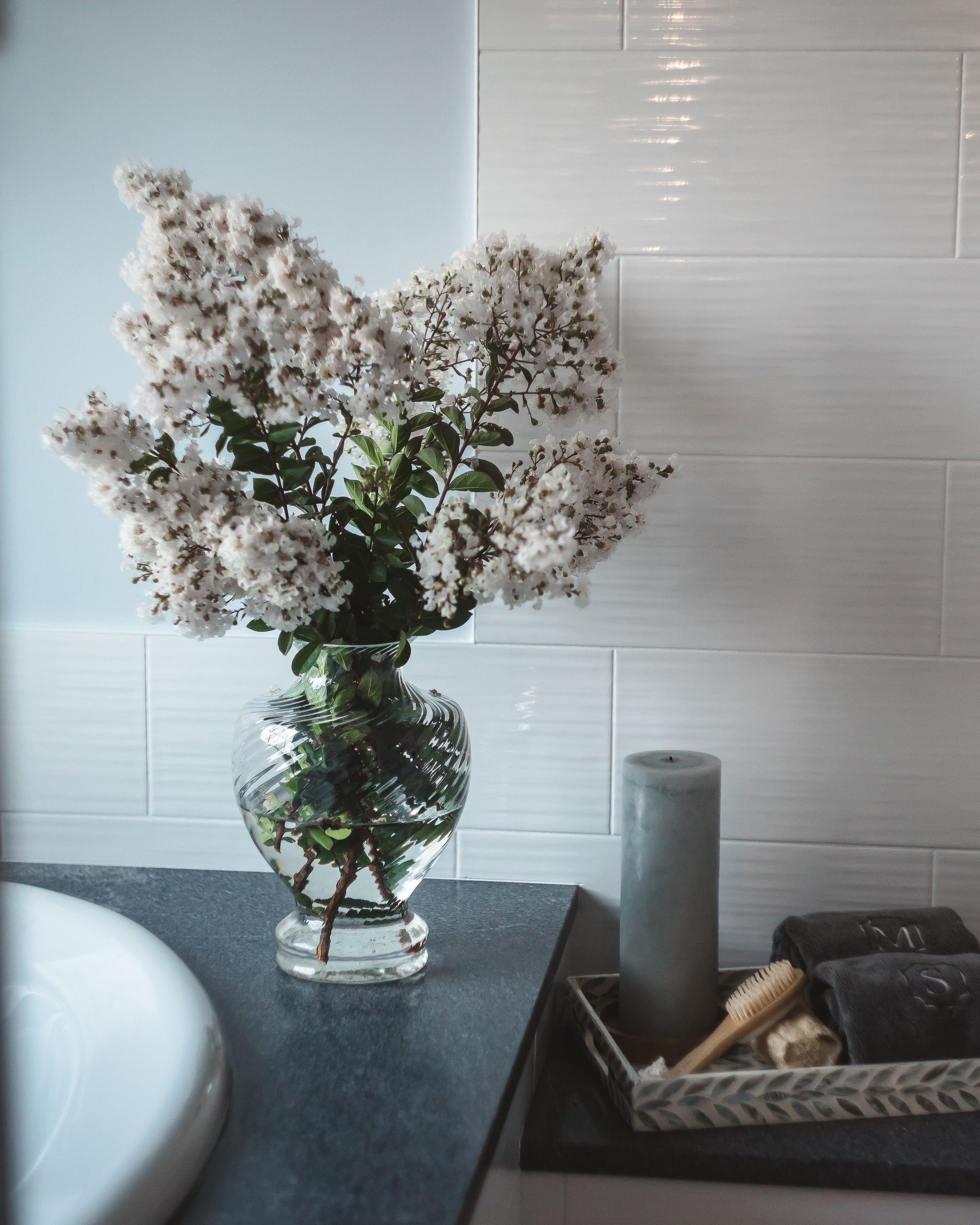 Delray Project - vase filled with white flowers sits on a bathroom counter