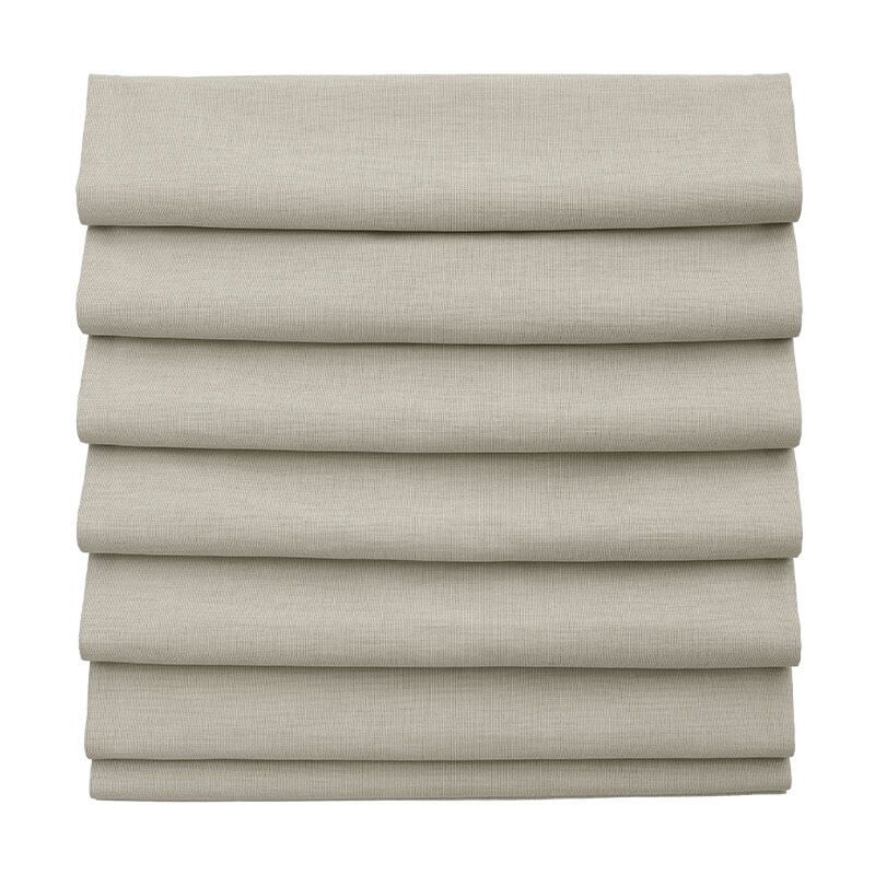 Stack of folded beige fabric blinds on a white background