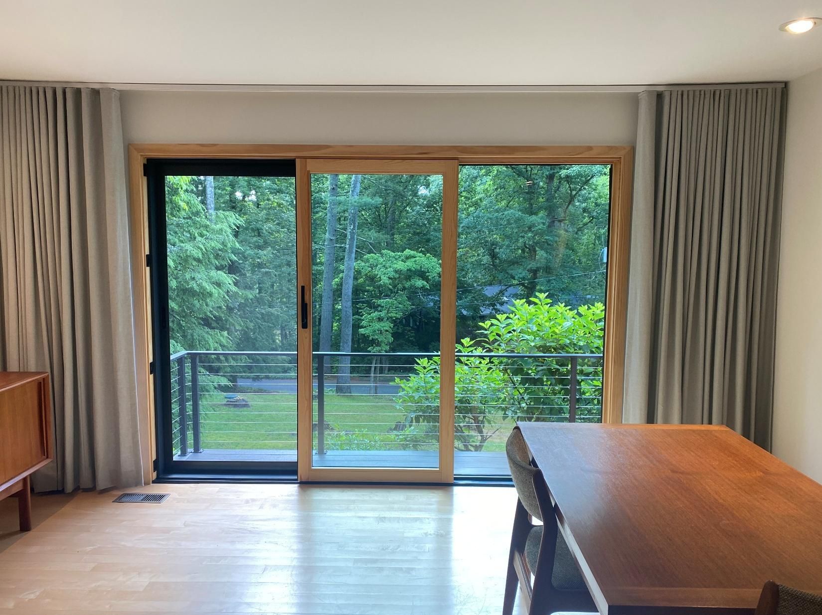 Bright living room with large sliding glass doors opening to a green backyard patio.