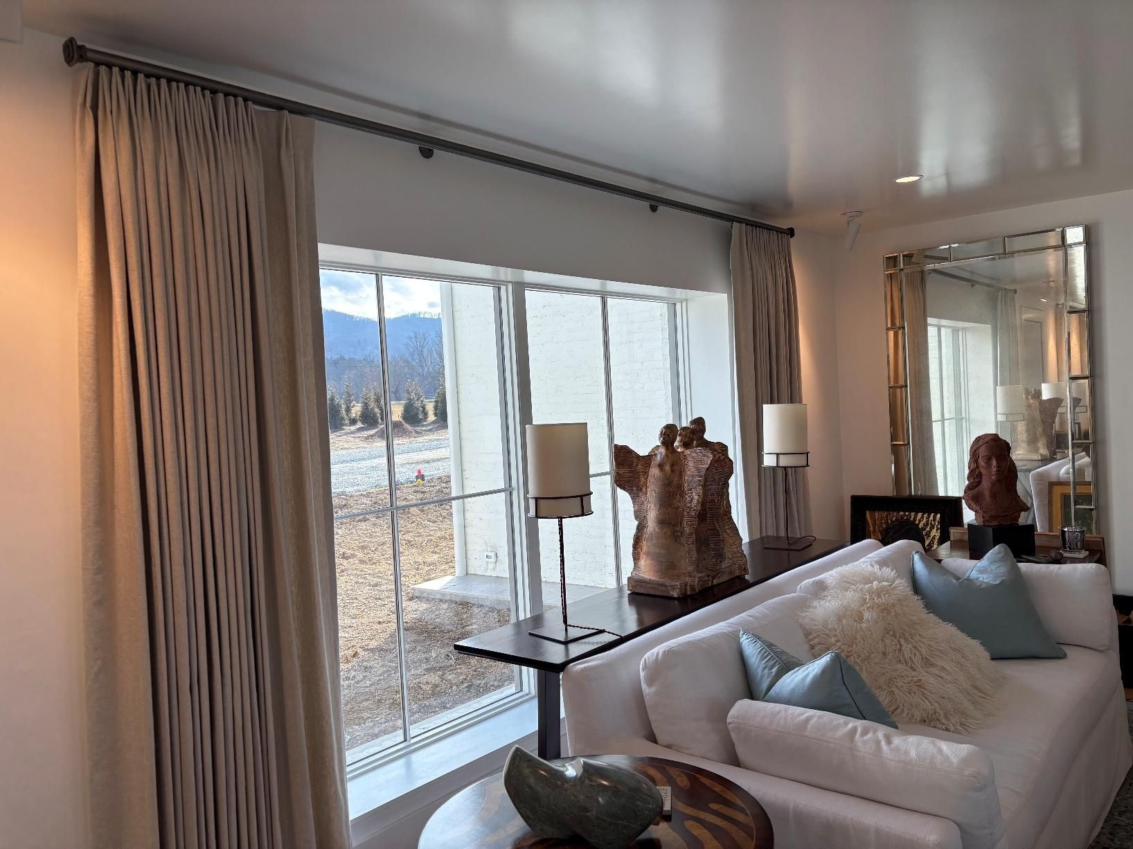 Bright living room with large windows, sofa, and decorative vases overlooking a snowy landscape