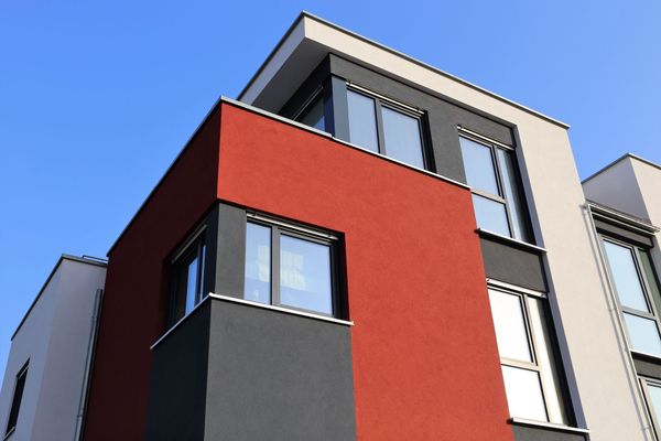 A red and black building with a blue sky in the background