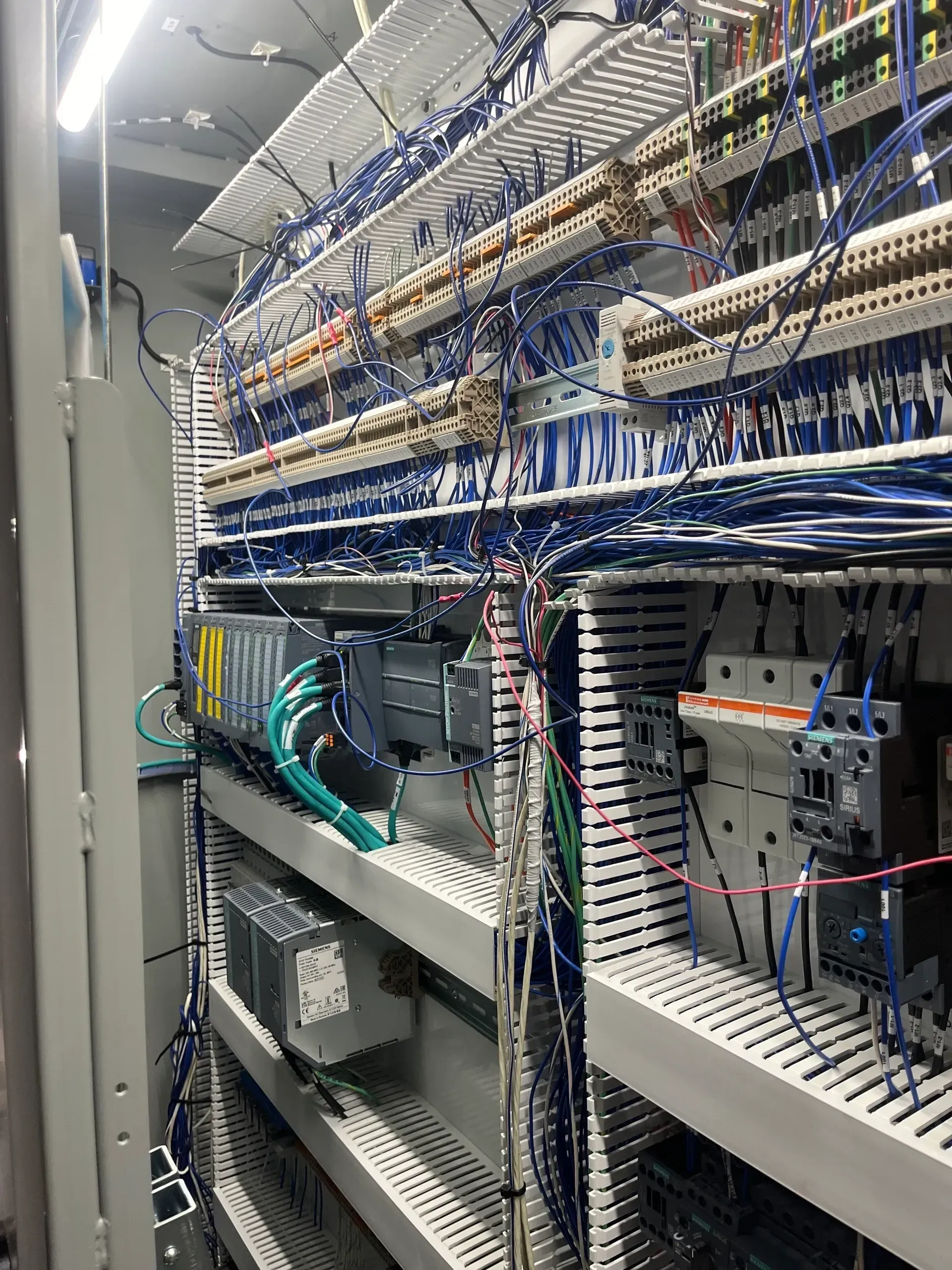 Control panel interior with numerous wires and electrical components.