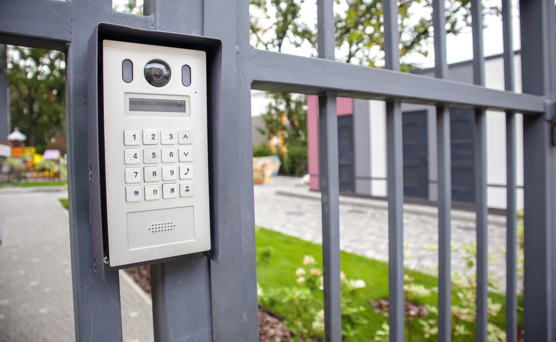A black sliding gate is sitting in front of a stone wall.