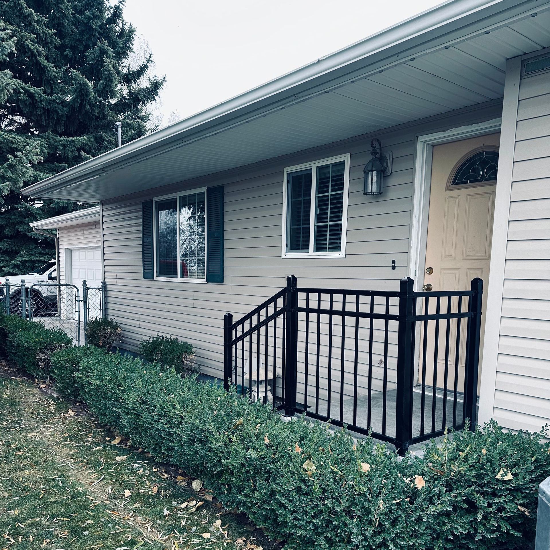 The front of a house with a black fence around it