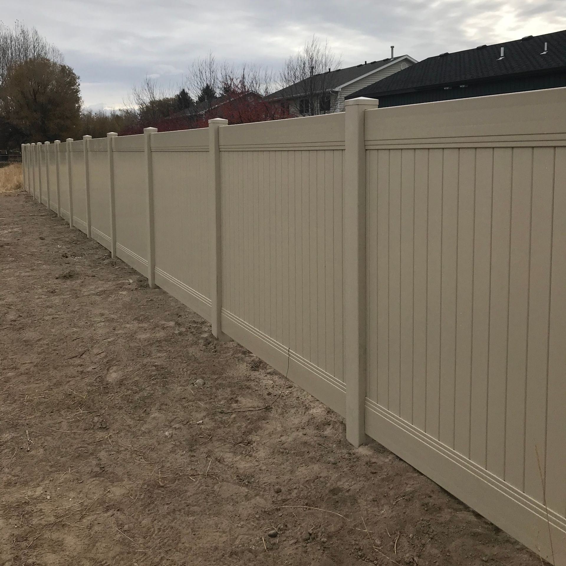 A white fence with a house in the background