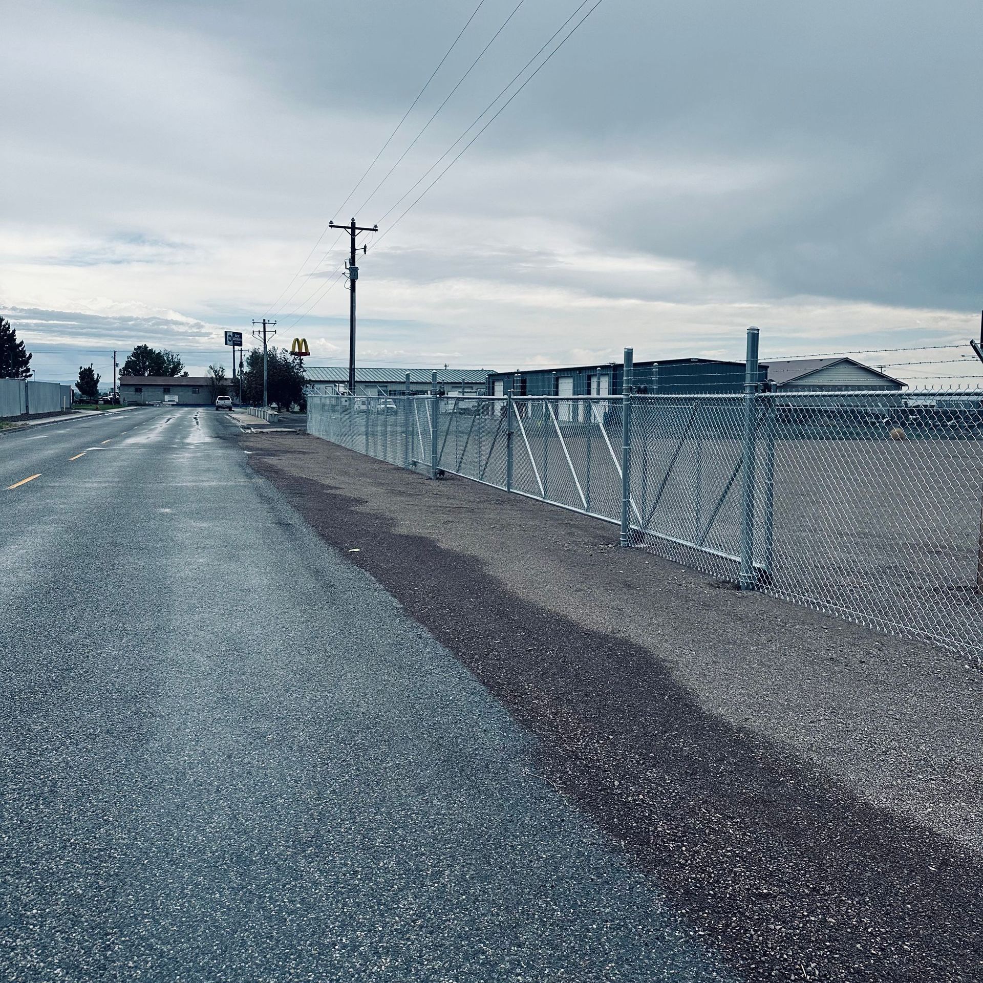 A chain link fence along the side of a road