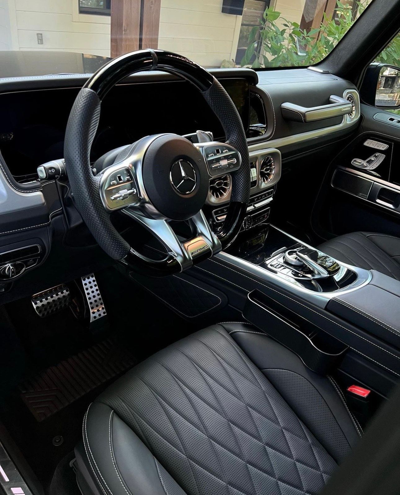 Black Mercedes-Benz G-Wagon interior; black leather seats, steering wheel, and silver accents.