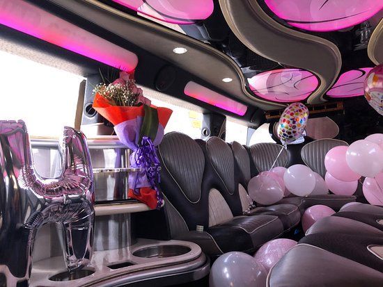 The inside of a limousine decorated with balloons and flowers.