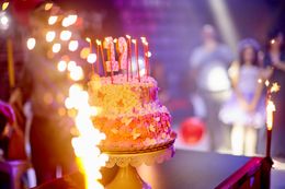 A birthday cake with candles on it is on a table.