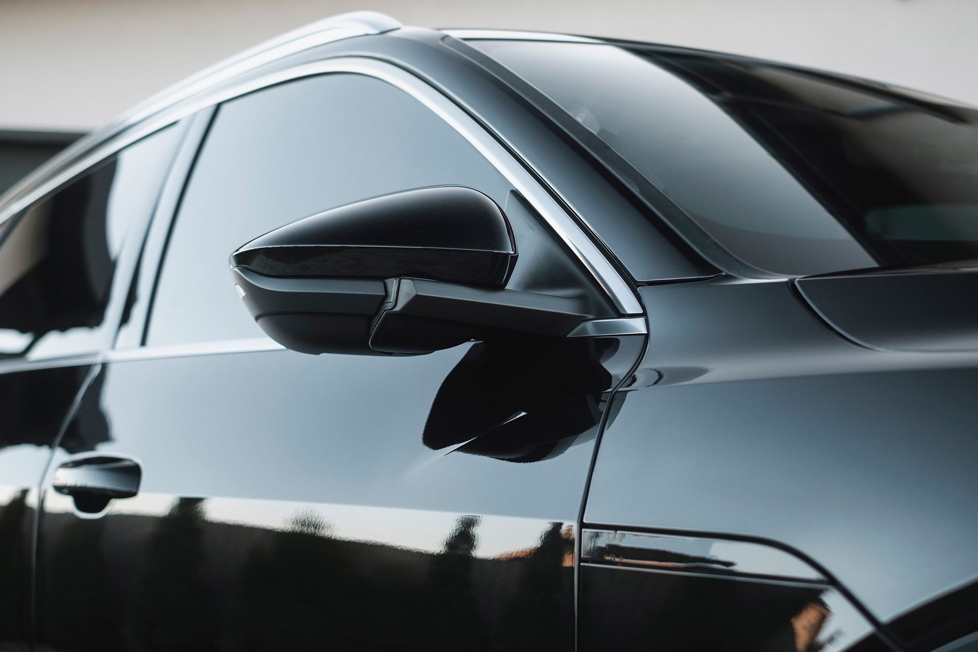 A close up of a black car parked in front of a building.