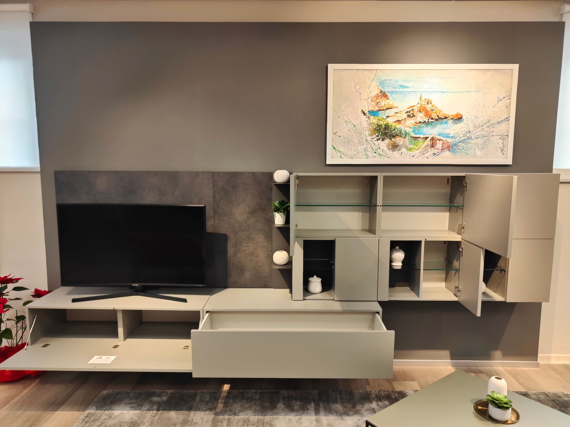 Un soggiorno con una tv e un quadro sul muro