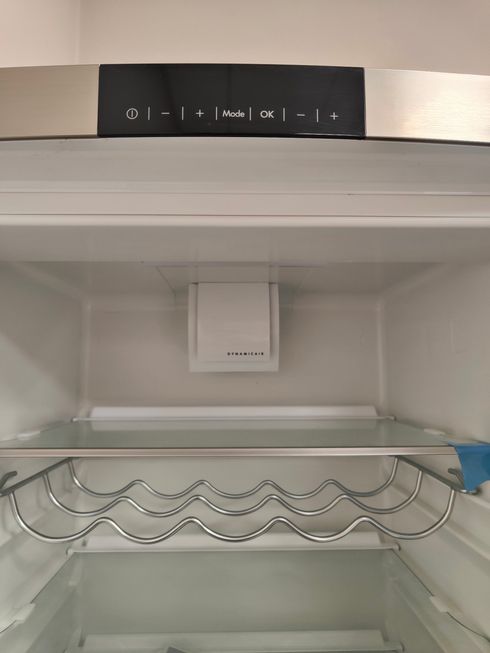 L'interno di un frigorifero vuoto con un portabottiglie.