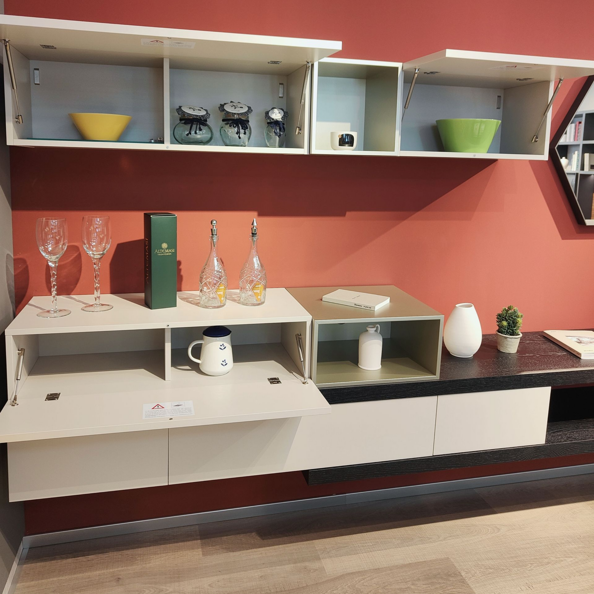 Un soggiorno con una parete rossa e mensole bianche