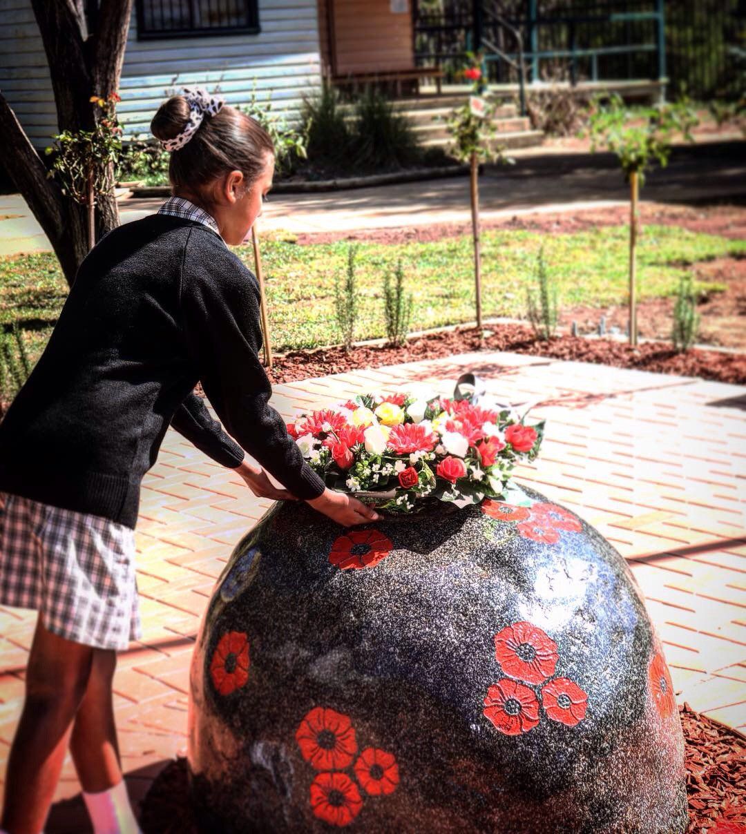 woman putting flowe on stone