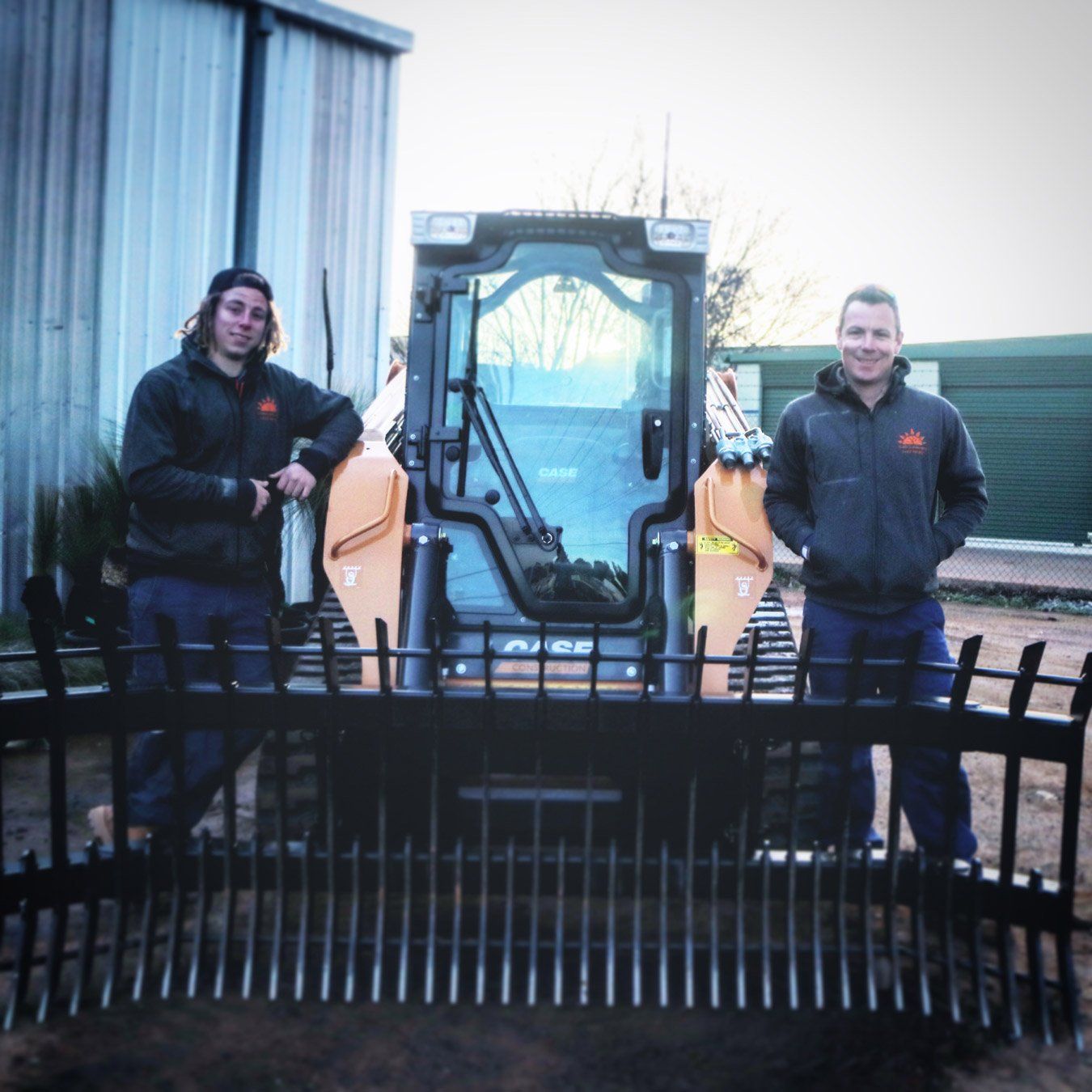 2 person posing beside a machine