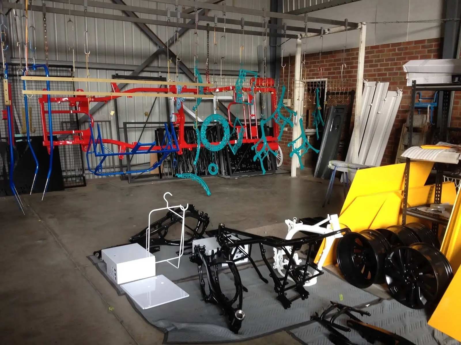 A Warehouse Filled With Lots Of Pieces Of Metal Including A Motorcycle Frame — Hunter Powder & Paints In Maitland, NSW
