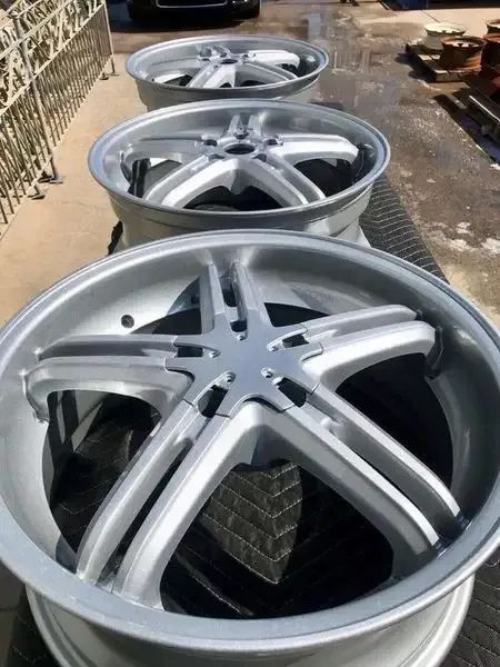 A Row Of Silver Wheels Are Sitting On Top Of A Black Tire — Hunter Powder & Paints In Lake Macquarie, NSW