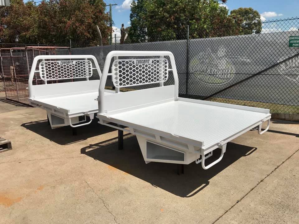 Two White Trays Sitting On The Ground In Front Of A Chain Link Fence — Hunter Powder & Paints In Rutherford, NSW