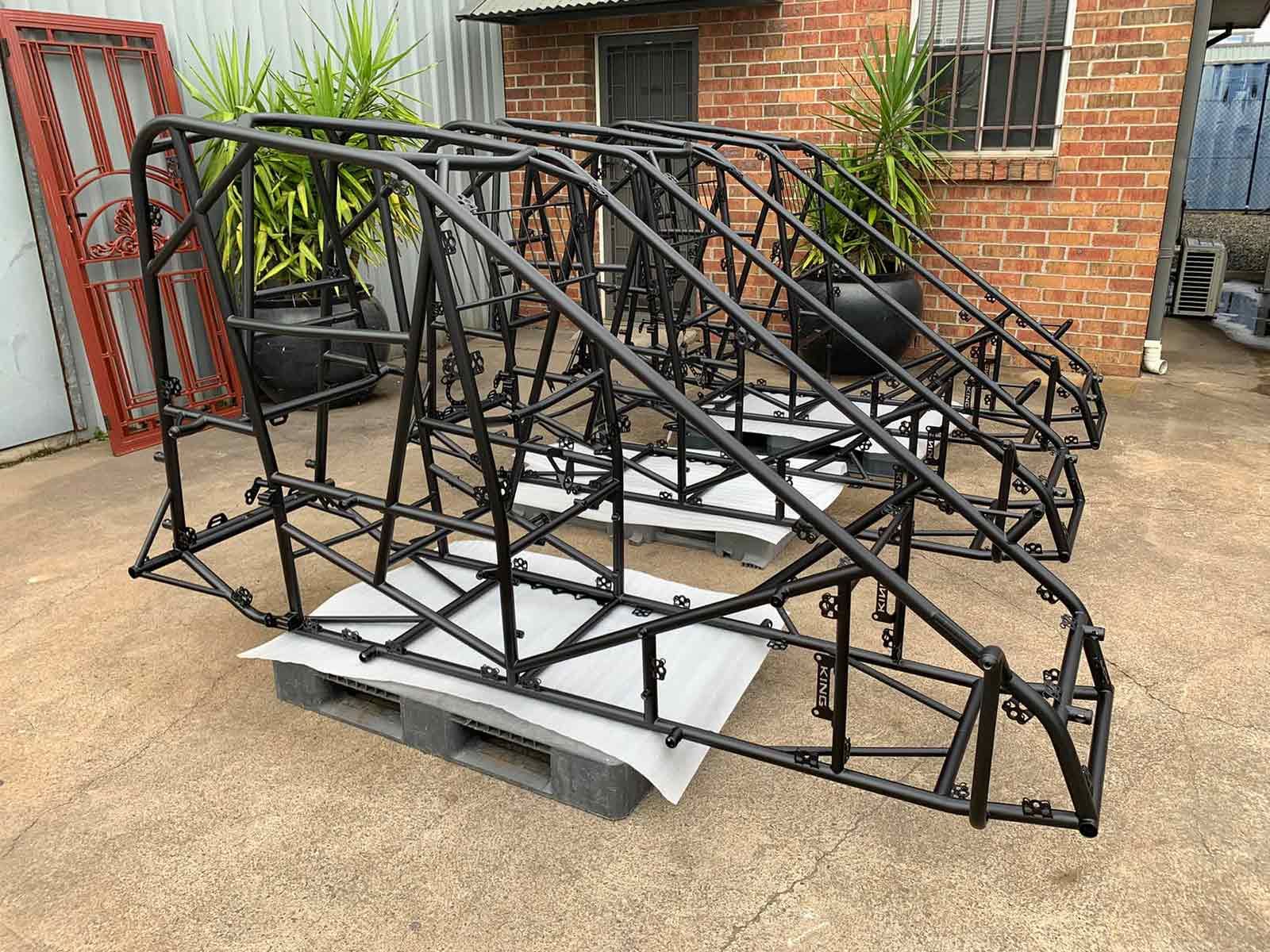 A Bunch Of Metal Frames Are Sitting On A Pallet In Front Of A Brick Building — Hunter Powder & Paints In Rutherford, NSW