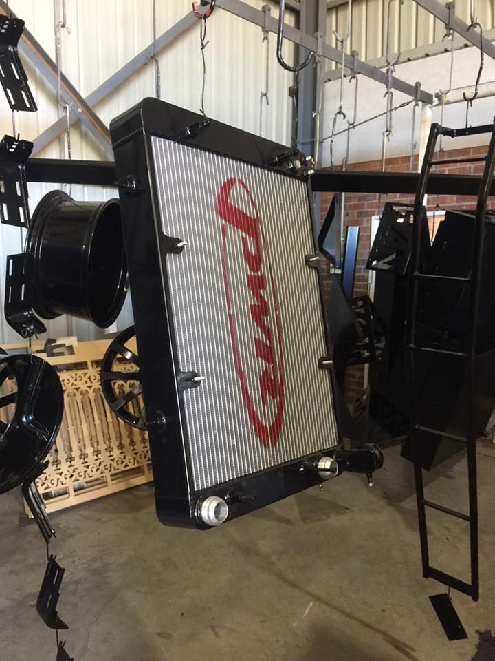 A Radiator Is Hanging From A Ladder In A Garage — Hunter Powder & Paints In Cessnock, NSW