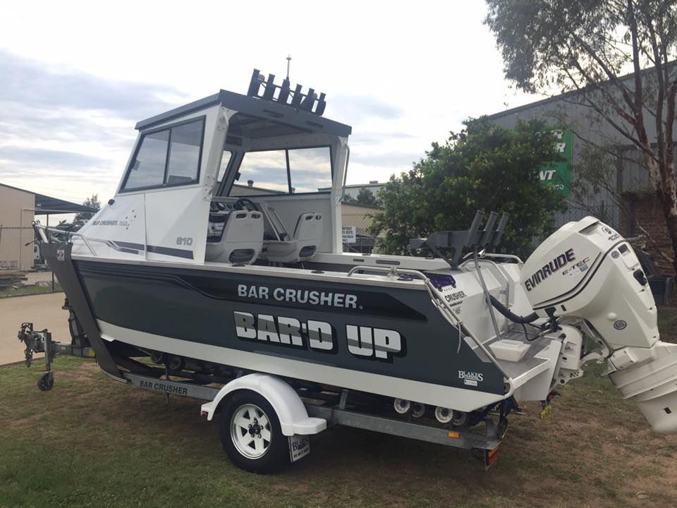 A Boat Is Parked On A Trailer In Front Of A Building — Hunter Powder & Paints In Cessnock, NSW