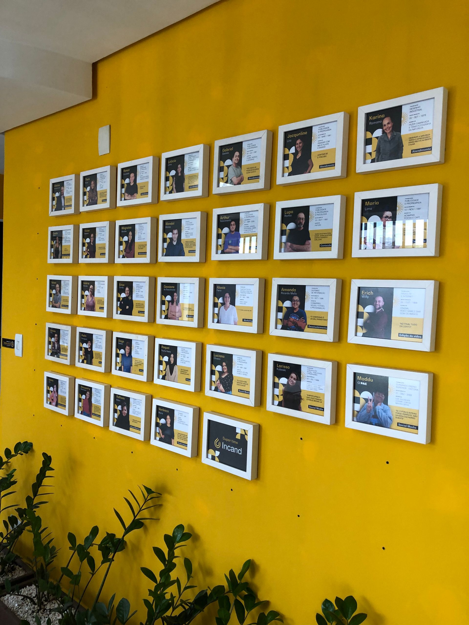 Uma parede amarela com um monte de fotos nela