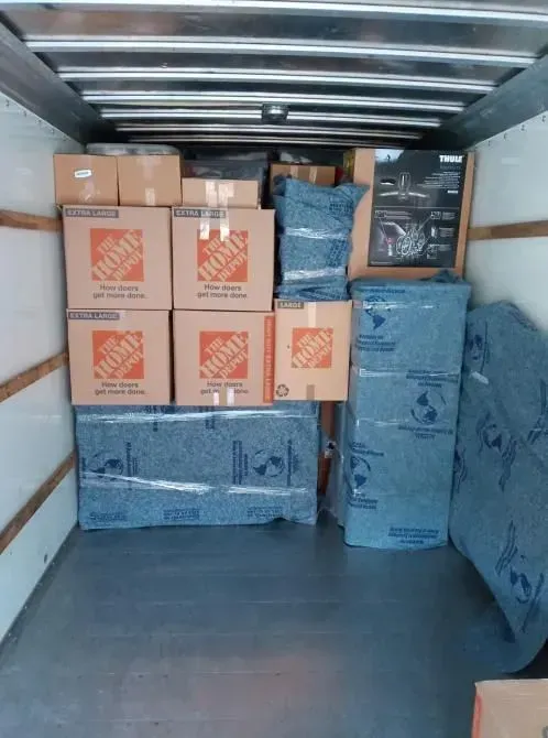 Boxes and furniture are packed inside a moving truck.