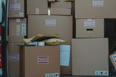 Boxes piled inside a delivery van, including shipping supplies, ready for transport.