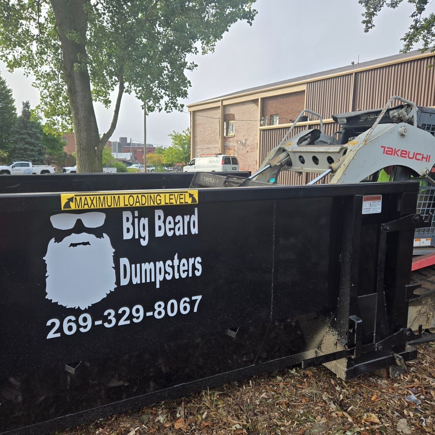 A dumpster for big beard dumpsters is sitting in front of a building