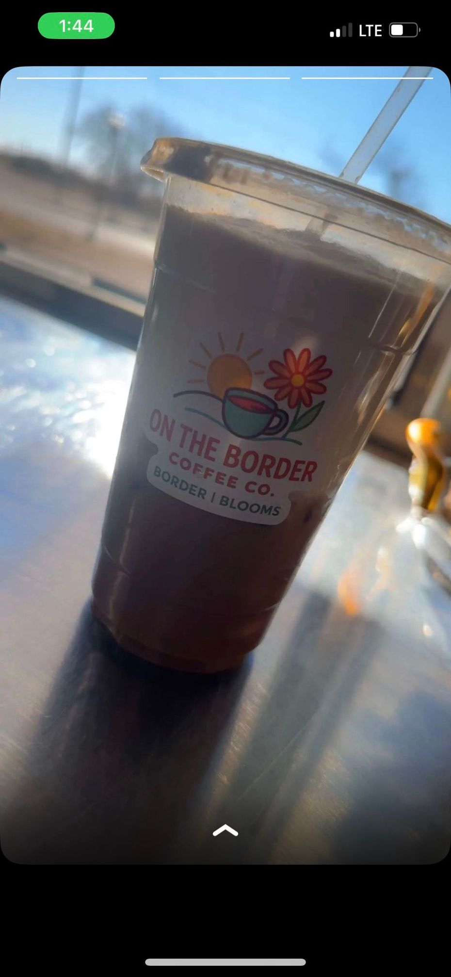 A clear plastic cup filled with a brown liquid, labeled