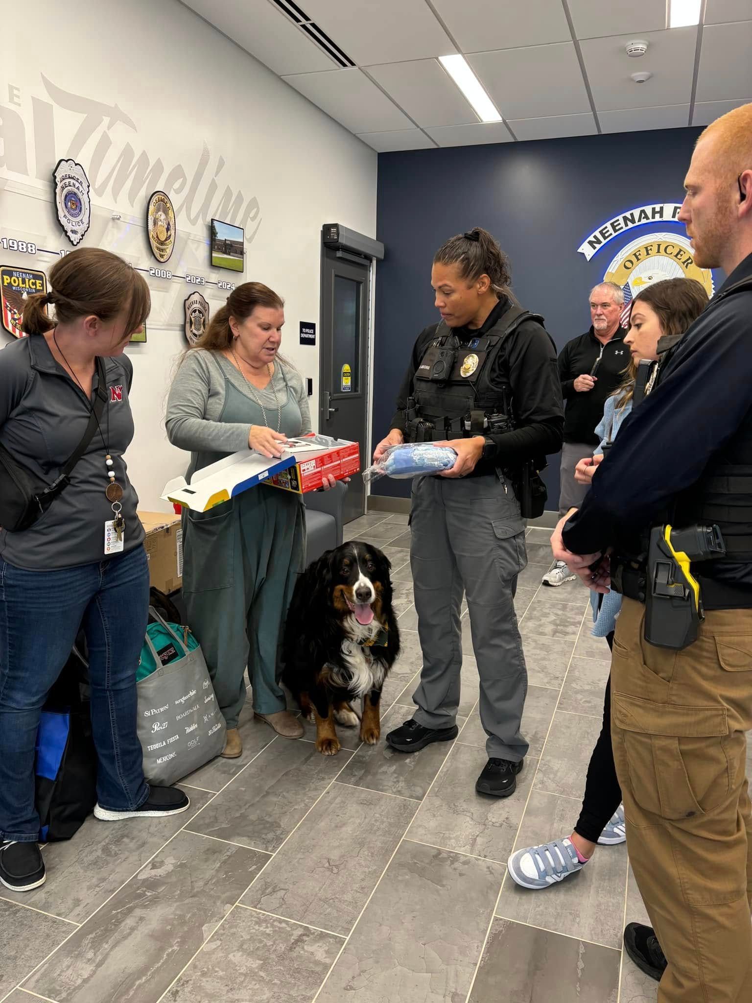 A group of people are standing around a dog in a room.