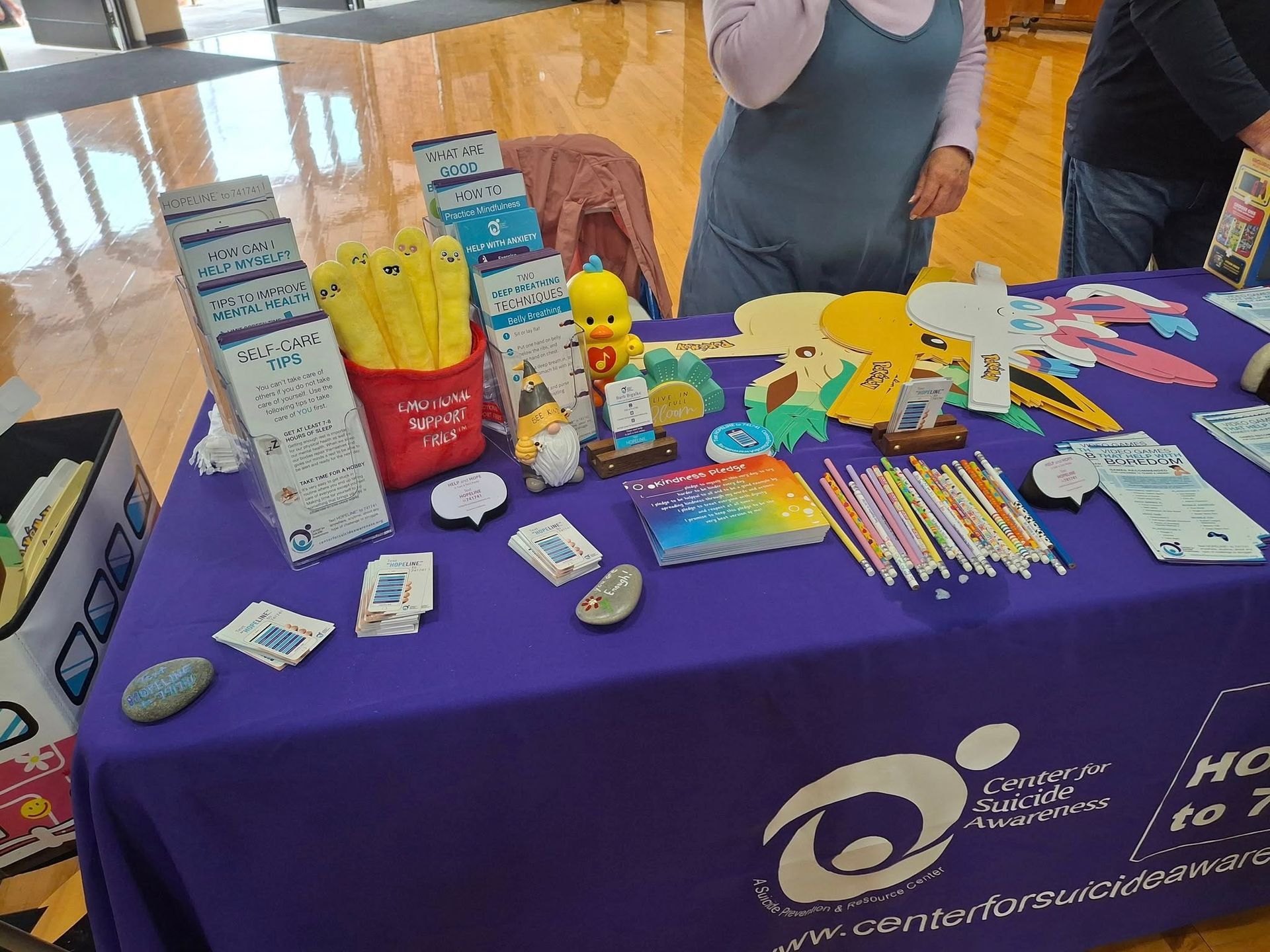 A table with a purple table cloth and a bunch of items on it