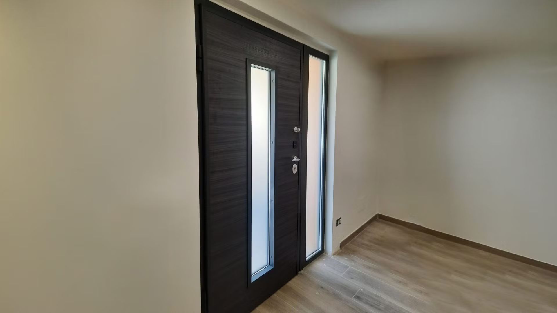 Un corridoio con una porta e una finestra in una casa.