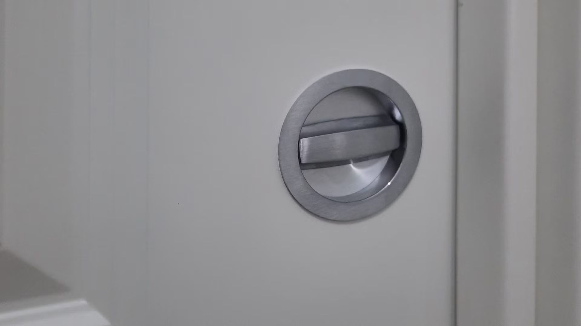 Un primo piano della maniglia di una porta bianca.