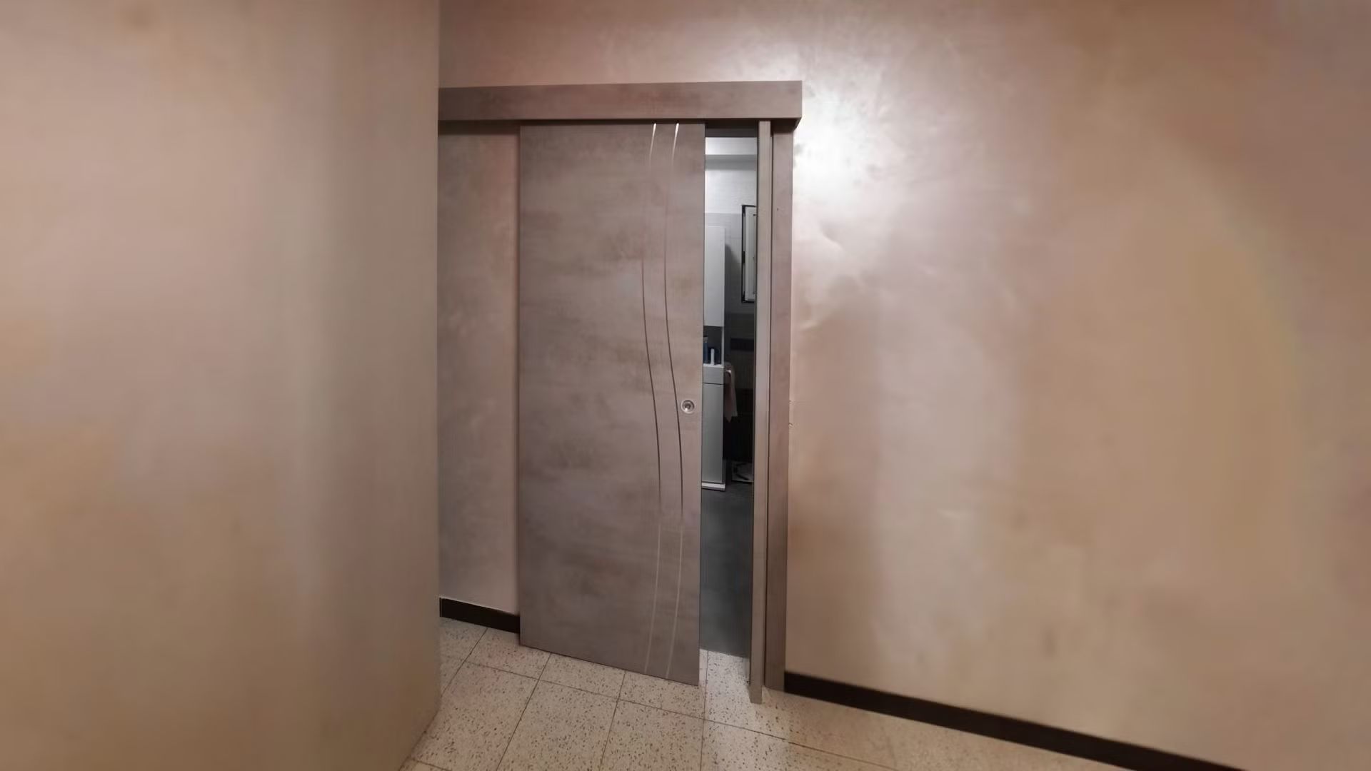 C'è una porta scorrevole in mezzo alla stanza.